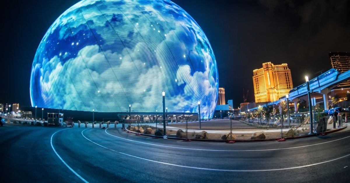 The Sphere at night, its exterior wrapped in a glowing blue cloud display, Las Vegas Strip in the background