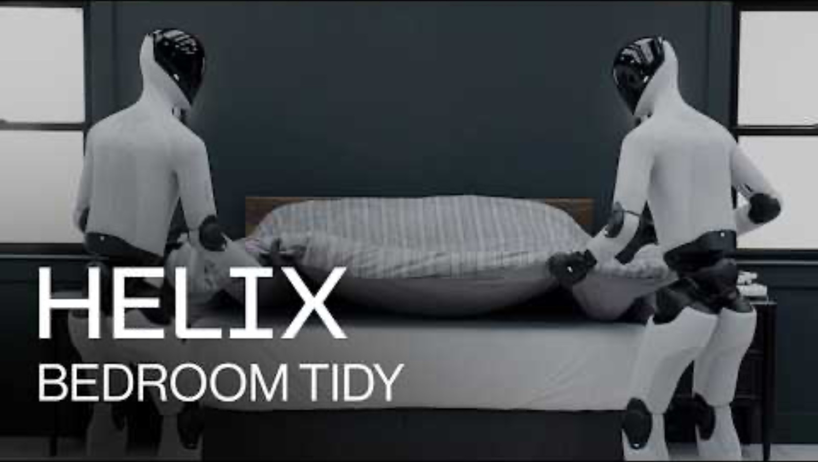 Two Helix humanoid robots making a bed together in a bedroom